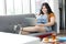 Smiling chubby woman looking hamburger and soft drink, during works from home or studying with computer laptop