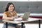 Smiling chubby woman works from home and studying with computer laptop