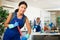 Smiling cleaning service workwoman mopping floors in office