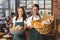 Smiling co-workers holding breads basket