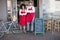 Smiling colleagues in red apron with arms crossed