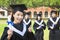 Smiling college graduate holds a diploma and thumb up