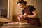 Smiling confectioner busy with making cookies on table in kitchen