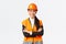 Smiling confident asian female chief manager at building, construction worker in safety helmet cross arms and looking