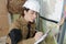 Smiling construction female worker holding clipboard