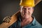 Smiling Contractor in Hard Hat Holding Plank of Wood i