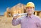 Smiling Contractor Wearing Hardhat Holding Blueprints at Home Co