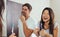 Smiling couple brushing teeth in bathroom