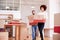 Smiling Couple Carrying Boxes Into New Home On Moving Day