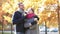 Smiling couple with coffee cups in autumn park