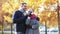 Smiling couple with coffee cups in autumn park