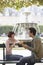 Smiling Couple Eating Baguette On Park Bench