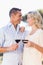 Smiling couple embracing, holding wineglass and looking at each other