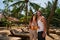 Smiling couple enjoys honeymoon in tropical paradise, sharing fresh coconut water. Fit man and woman in summer attire