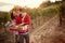 Smiling couple gather harvest grapes