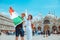 smiling couple holding italian flag venice central square san marco