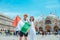 smiling couple holding italian flag venice central square san marco