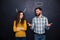 Smiling couple imitating devil and angel over chalkboard background