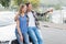 Smiling couple leaning on the bonnet