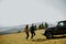 Smiling couple preparing hiking adventure with backpacks by terrain vehicle