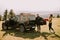 Smiling couple preparing hiking adventure with backpacks by terrain vehicle