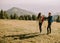 Smiling couple preparing hiking adventure with backpacks by terrain vehicle