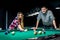 Smiling couple in pub playing billiard