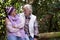 A smiling couple of senior retired people enjoying the hike in the woods during the fall season, hugging and looking each other in