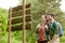 Smiling couple at signpost with backpacks hiking