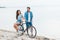 smiling couple sitting on bike on beach