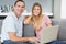 Smiling couple sitting using laptop on the couch together