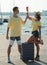 Smiling couple with suitcase on the beach