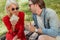 smiling couple in sunglasses eating sandwiches at picnic