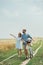 smiling couple in sunglasses with retro bicycle in summer field