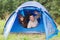 Smiling couple of tourists looking out from tent