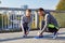 Smiling couple tying shoelaces outdoors