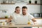 Smiling couple watching funny video on computer while having bre