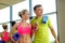 Smiling couple with water bottles in gym