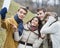 Smiling couples taking self portrait through cell phone in park