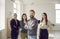 Smiling coworkers stand looking at camera creating team shots in office together.