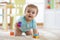 Smiling crawling baby boy on living room floor, caucasian child