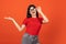 Smiling. Cropped portrait of young beautiful expressive girl isolated on orange studio background