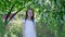 Smiling curly girl portrait in sunny garden on blooming fruit trees background. Happy girl model posing in blooming