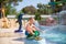 Smiling cute boy has fun in the pool at the aquapark. Activities in the pool. Concept summer vacation, rest, fun