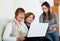 Smiling cute girl teaching positive senior women using laptop