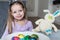 Smiling cute kid with easter eggs and plush bunny. Easter