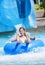 Smiling Cute little girl riding down a water slide at a water park