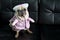 Smiling cute pug dog dressed like a nurse. Pug dog wearing costume sitting on sofa with tongue sticking out