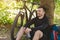 Smiling cyclist resting under tree in mountain forest