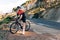 Smiling cyclist standing on a roadside in wild terrain